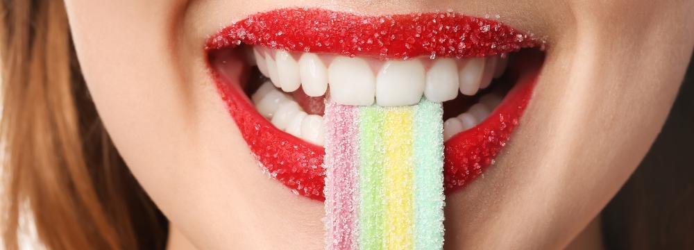 A woman with sugar on her lips eating candy