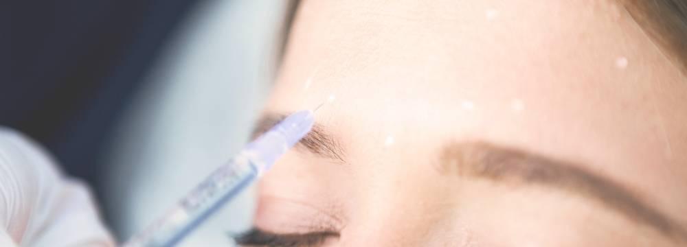 Woman getting injections into eyebrow